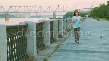 穿着蓝色T恤的运动女孩在长廊上奔跑。 慢动作